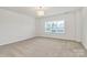 This spacious bedroom features neutral carpet, a modern light fixture and a large window at 163 Crenshaw Nw Pl, Concord, NC 28027