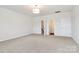 This spacious bedroom features neutral carpet, a modern light fixture, and two entryways at 163 Crenshaw Nw Pl, Concord, NC 28027