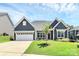 Charming home showcasing well-maintained lawn, blue siding, and inviting two-car garage at 163 Crenshaw Nw Pl, Concord, NC 28027