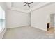 Spacious main bedroom featuring tray ceilings, a ceiling fan, and neutral carpeting at 163 Crenshaw Nw Pl, Concord, NC 28027