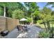Private backyard offering a patio seating area, mature trees, and manicured landscaping at 1715 Wensley Dr, Charlotte, NC 28210