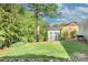 Backyard featuring well-manicured lawn, established landscaping, storage shed and rock border at 1715 Wensley Dr, Charlotte, NC 28210