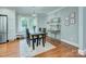 Traditional dining room with hardwood floors, large window, elegant lighting, and stylish bar area for entertaining at 1715 Wensley Dr, Charlotte, NC 28210