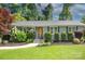 Charming single-story home featuring manicured landscaping, gray brick accents and a cozy front porch at 1715 Wensley Dr, Charlotte, NC 28210