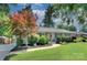 Charming single-story home with a beautifully landscaped front yard, a mature tree and a sidewalk leading to the front door at 1715 Wensley Dr, Charlotte, NC 28210