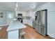 Well-appointed kitchen with stainless steel appliances, white cabinetry, and hardwood floors at 1715 Wensley Dr, Charlotte, NC 28210