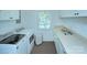 Bright laundry room featuring modern washer and dryer, ample counter space, and natural light from a window at 1715 Wensley Dr, Charlotte, NC 28210