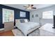 Cozy main bedroom featuring a queen-sized bed, hardwood floors, neutral colors, ceiling fan, and bright windows at 1715 Wensley Dr, Charlotte, NC 28210