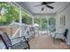 Inviting screened porch with comfortable seating, ceiling fan, and views of the lush, landscaped backyard at 1715 Wensley Dr, Charlotte, NC 28210