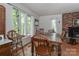 Cozy dining room with hardwood floors, a brick fireplace, and large windows with natural lighting at 173 Rocky River Rd, Mooresville, NC 28115