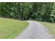 Gravel driveway leading up to the property with split rail fence on the hillside at 173 Rocky River Rd, Mooresville, NC 28115