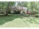 Charming two-story home featuring a lush green lawn, mature trees, and a cozy deck at 173 Rocky River Rd, Mooresville, NC 28115