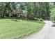 Exterior view of home with a long driveway, and a well-manicured lawn at 173 Rocky River Rd, Mooresville, NC 28115