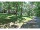 Exterior view of home nestled among trees on a sunny, grassy lot at 173 Rocky River Rd, Mooresville, NC 28115