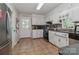 Traditional kitchen features tile flooring, white cabinetry, and stainless steel appliances at 173 Rocky River Rd, Mooresville, NC 28115