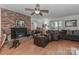 Warm living room with hardwood floors, brick fireplace, ceiling fan and comfortable seating at 173 Rocky River Rd, Mooresville, NC 28115