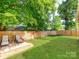 Spacious backyard offers lounge chairs, hammock, large grassy area, and partial wood privacy fence at 1817 Rush Wind Dr, Charlotte, NC 28206