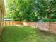 Spacious backyard with a lush lawn, wood fence, a hammock, and a seating area at 1817 Rush Wind Dr, Charlotte, NC 28206