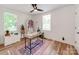 Home office with hardwood floors, desk, office chair, bookshelf, and two large windows at 1817 Rush Wind Dr, Charlotte, NC 28206