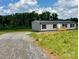 Exterior of the home shows neutral siding, a small deck, black shutters, and a gravel driveway at 188 Trivette Rd, Harmony, NC 28634