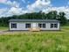 Charming single-story home with gray siding, black shutters, and a welcoming front porch in a serene setting at 188 Trivette Rd, Harmony, NC 28634