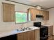 Well-lit kitchen with white countertops, wood cabinets, and a stainless steel sink under the window at 188 Trivette Rd, Harmony, NC 28634