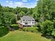 Aerial view of the back of the home, showing the deck, manicured lawn and landscaping at 19946 River Falls Dr, Davidson, NC 28036