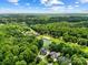 Wide aerial perspective of the property showcasing lush trees, golf course, water features, and nearby homes at 19946 River Falls Dr, Davidson, NC 28036