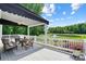 This back porch overlooks a beautiful green landscape and pond with outdoor furniture and an awning at 19946 River Falls Dr, Davidson, NC 28036