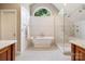 Luxurious bathroom featuring a soaking tub, a frameless glass shower, and elegant white tile at 19946 River Falls Dr, Davidson, NC 28036