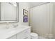 Clean bathroom with a single sink vanity, a framed mirror, and a shower-tub combo at 19946 River Falls Dr, Davidson, NC 28036