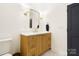 Stylish bathroom featuring a wood vanity with light countertops, gold fixtures, and modern lighting at 19946 River Falls Dr, Davidson, NC 28036