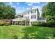 Expansive back of the home with a spacious white deck, large lawn, and lush landscaping, perfect for outdoor living at 19946 River Falls Dr, Davidson, NC 28036