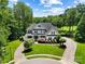 Stately two-story home with meticulously landscaped front yard, circular driveway, and lush surrounding trees at 19946 River Falls Dr, Davidson, NC 28036