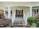Inviting front porch featuring double doors, stone steps, fresh plants, and an ADT security sign at 19946 River Falls Dr, Davidson, NC 28036