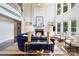 Bright living room with fireplace, built-in shelving, soaring windows, and a blue velvet couch at 19946 River Falls Dr, Davidson, NC 28036