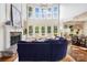 Elegant living room featuring a stone fireplace, floor to ceiling windows and comfortable blue sofa at 19946 River Falls Dr, Davidson, NC 28036