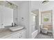 Bright bathroom featuring modern sink, elegant vanity, and a shower/tub with glass doors at 211 Ridgecrest St, Kannapolis, NC 28081