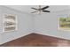 Bright bedroom features hardwood floors, neutral walls, a ceiling fan, and natural light from two windows at 211 Ridgecrest St, Kannapolis, NC 28081