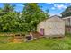 An exterior shot of a shed with a fire pit, trees, and green grass at 211 Ridgecrest St, Kannapolis, NC 28081
