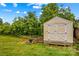 An exterior shot of a yellow shed and trees with green grass at 211 Ridgecrest St, Kannapolis, NC 28081