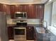 Well-equipped kitchen with stainless steel appliances, dark countertops, and wooden cabinetry at 2958 Iron Gate Ln, Charlotte, NC 28212