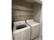 Functional laundry area with white washer, dryer and ample shelving at 2958 Iron Gate Ln, Charlotte, NC 28212