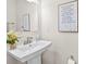 Well-lit bathroom with a pedestal sink, decorative mirror, and inspirational wall art at 3748 Ellington St, Charlotte, NC 28211