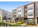 View of new townhomes with a combination of brick and gray siding, well-manicured lawns, and a black fence at 3748 Ellington St, Charlotte, NC 28211
