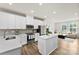 Bright kitchen with white cabinetry, an island, stainless appliances, and an open view to the living room at 3748 Ellington St, Charlotte, NC 28211