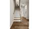 Hallway with staircase featuring wood treads, white risers, and wooden handrail and white walls at 3748 Ellington St, Charlotte, NC 28211