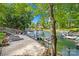 Lakeside backyard featuring a sandy beach, dock, and sun loungers, perfect for waterfront relaxation and recreation at 4120 Lake Shore S Rd, Denver, NC 28037
