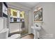 Well-lit bathroom with pedestal sink and sliding glass door to the outside patio at 415 W 7Th St # H, Charlotte, NC 28202