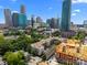 An eye-level view of tree coverage, apartment complex, and skyline, highlighting the desirable urban setting at 415 W 7Th St # H, Charlotte, NC 28202